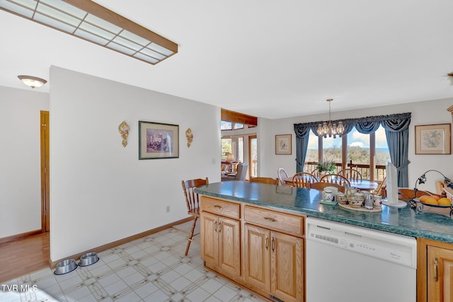 kitchen featuring pendant lighting, light brown cabinetry, a chandelier, and dishwasher