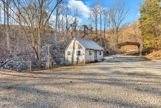 exterior space with a carport and an outdoor structure