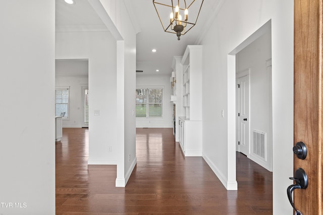 foyer with a chandelier, crown molding, and a healthy amount of sunlight