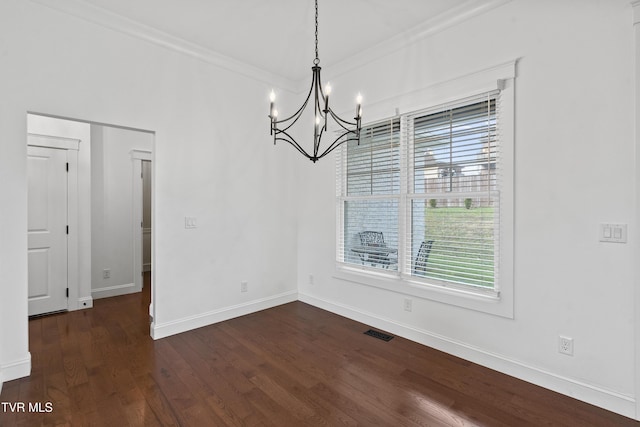 unfurnished dining area featuring dark hardwood / wood-style flooring, a healthy amount of sunlight, a notable chandelier, and ornamental molding