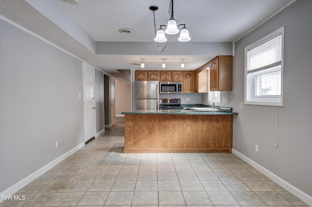 kitchen featuring light tile patterned floors, a textured ceiling, appliances with stainless steel finishes, decorative light fixtures, and kitchen peninsula