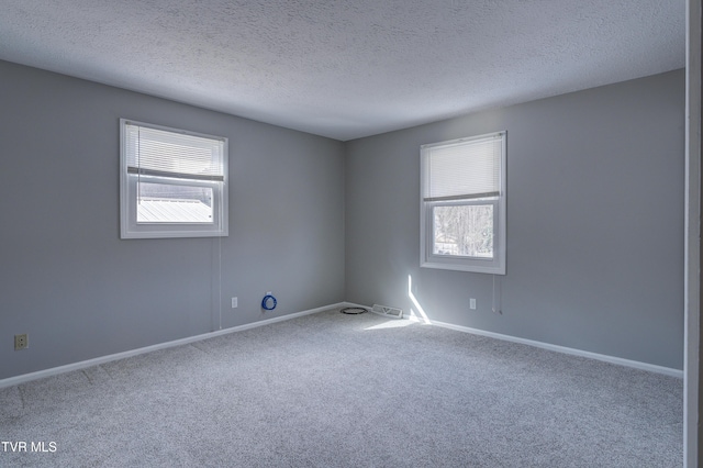 carpeted spare room featuring a textured ceiling