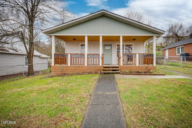 bungalow featuring covered porch and a front yard