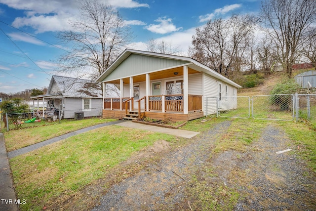 bungalow-style house with a porch, a front yard, and central AC