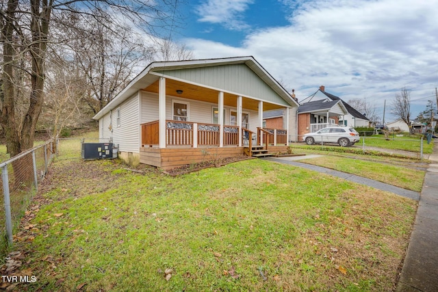 bungalow-style home featuring covered porch, central air condition unit, and a front lawn