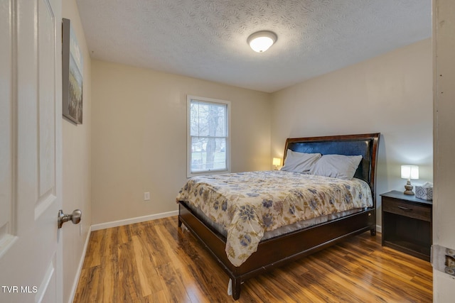 bedroom with hardwood / wood-style flooring and a textured ceiling