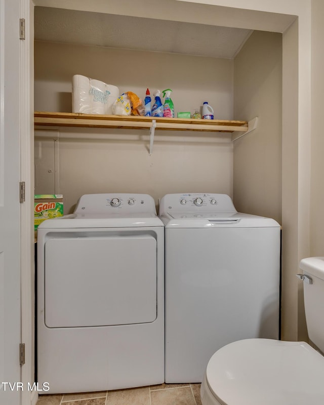 clothes washing area with independent washer and dryer and light tile patterned floors