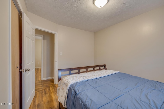 bedroom with wood-type flooring and a textured ceiling