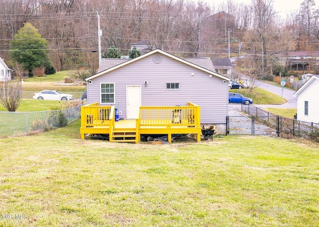 rear view of property featuring a lawn and a deck