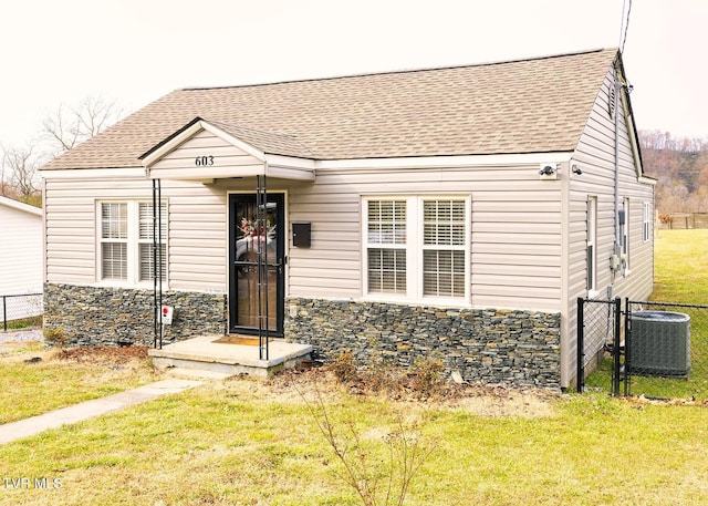 view of front of home with central air condition unit and a front lawn