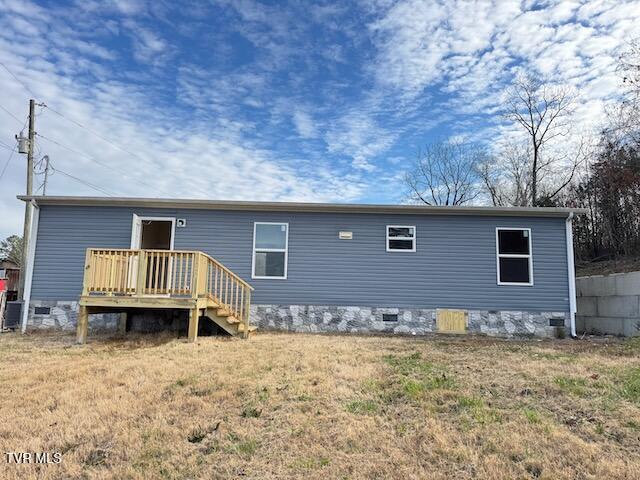 rear view of house with a lawn and a deck