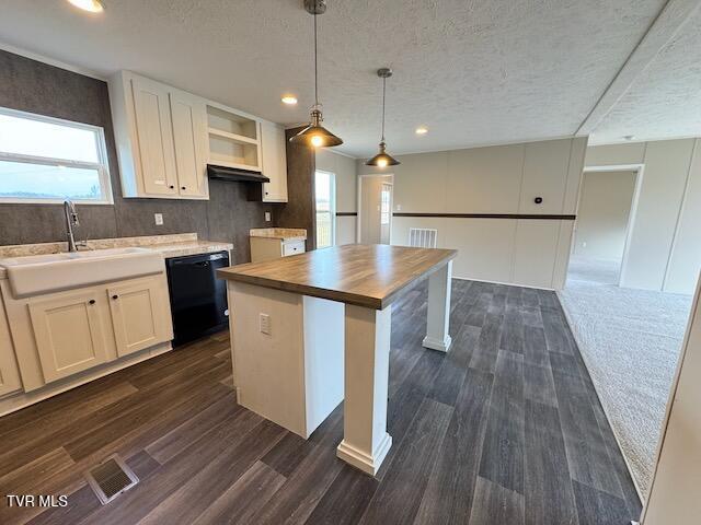 kitchen with white cabinets, sink, pendant lighting, dishwasher, and a kitchen island