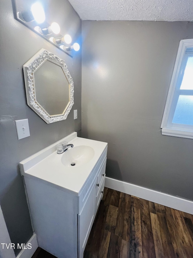 bathroom with vanity, wood-type flooring, and a textured ceiling