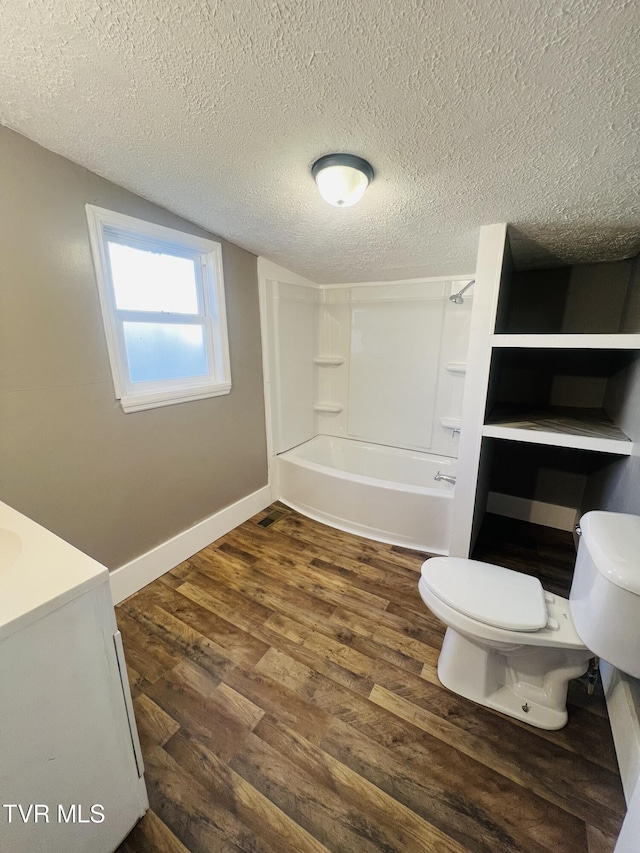 full bathroom featuring shower / bathing tub combination, vanity, toilet, a textured ceiling, and wood-type flooring