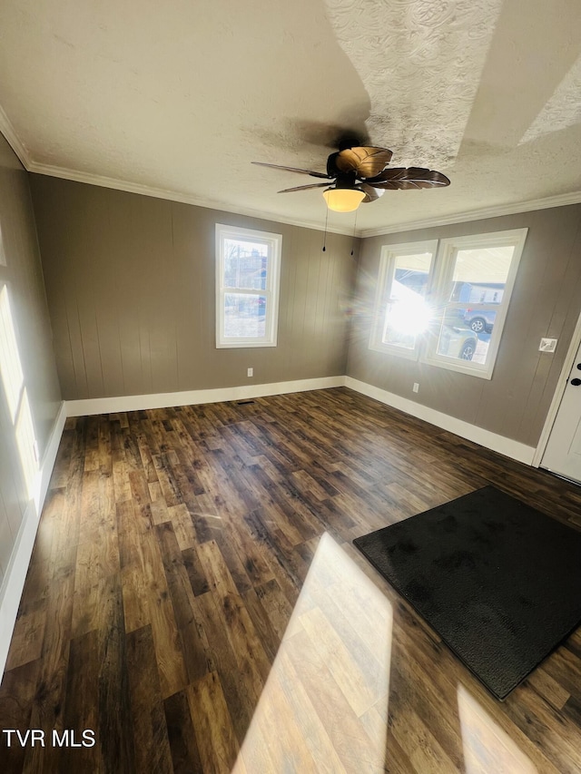 unfurnished room with a textured ceiling, dark hardwood / wood-style floors, ceiling fan, and crown molding