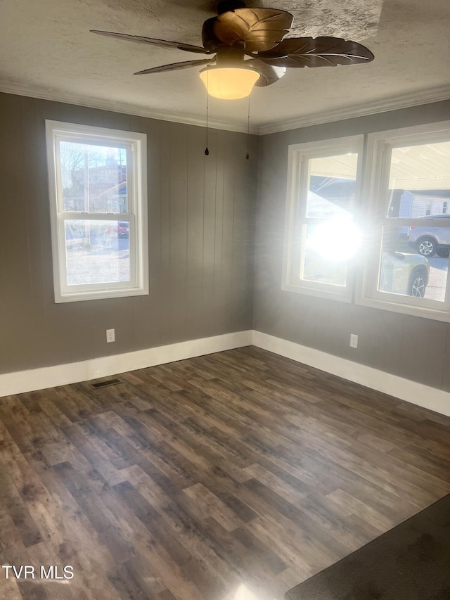 spare room featuring ceiling fan, crown molding, and dark wood-type flooring