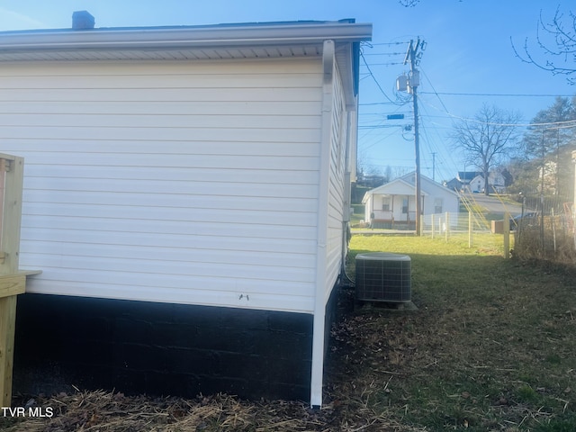 view of side of property featuring a lawn and cooling unit