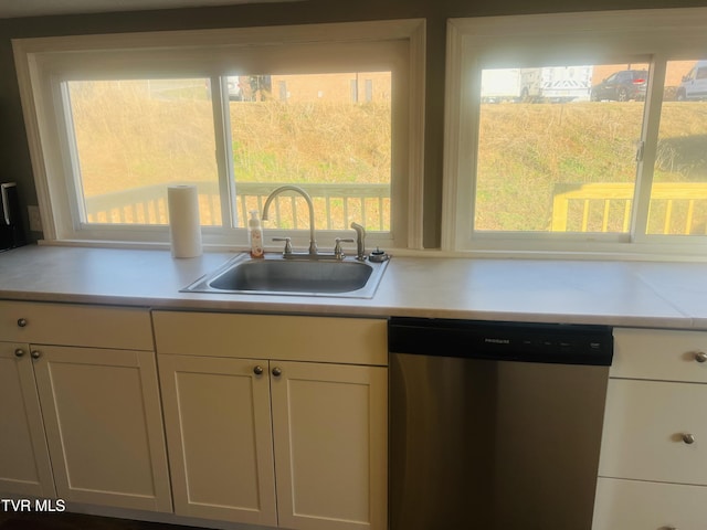 kitchen featuring white cabinets, stainless steel dishwasher, and sink