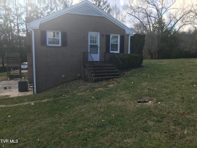 view of home's exterior with brick siding, central air condition unit, and a lawn