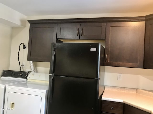 kitchen with black refrigerator, separate washer and dryer, and dark brown cabinets