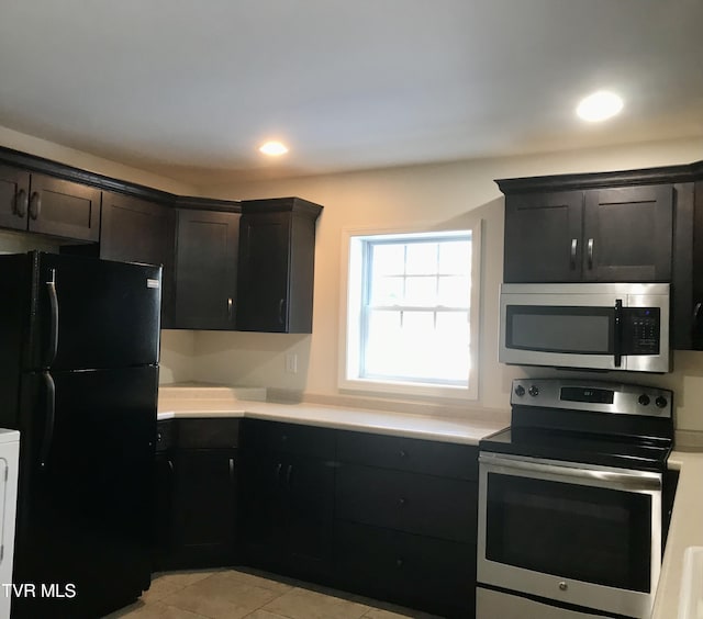 kitchen with light tile patterned flooring, stainless steel appliances, and dark brown cabinetry