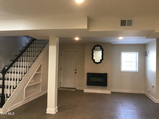 basement with built in features and dark tile patterned flooring