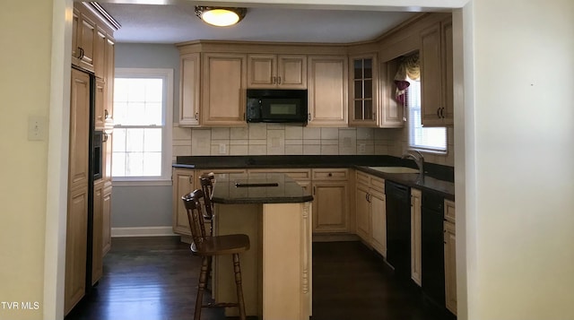 kitchen with a breakfast bar area, tasteful backsplash, dark hardwood / wood-style flooring, black appliances, and sink