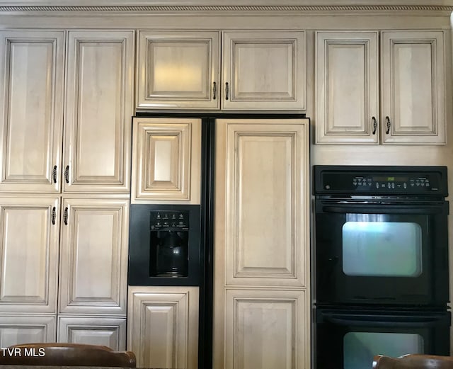 kitchen with cream cabinetry, paneled fridge, and dobule oven black