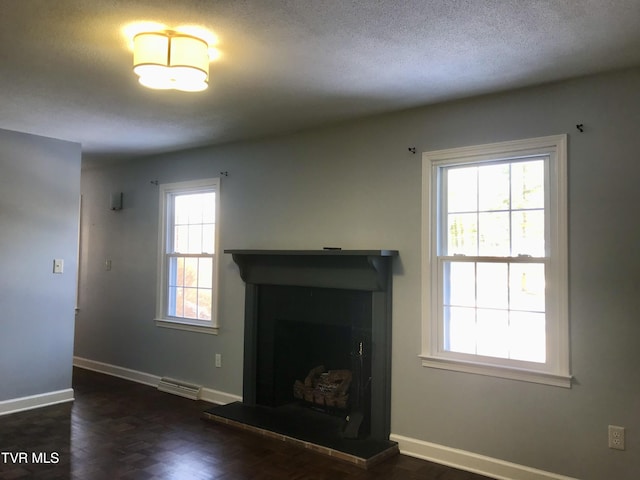 unfurnished living room featuring a wealth of natural light and a textured ceiling