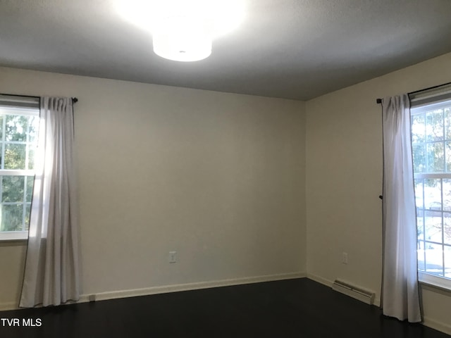 unfurnished room with a baseboard heating unit