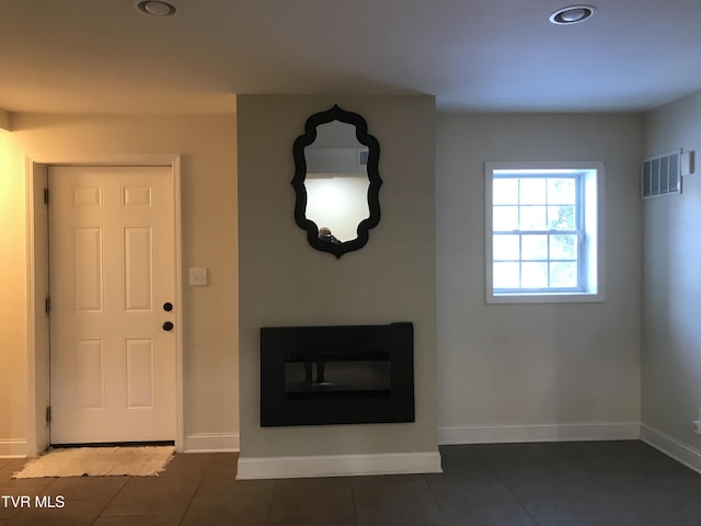 unfurnished living room featuring dark tile patterned flooring