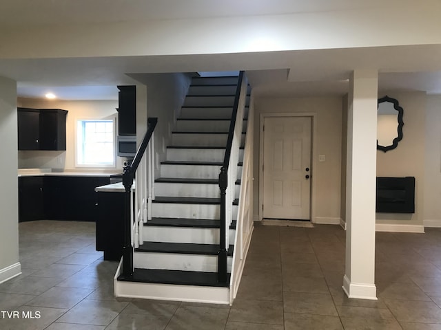 stairs featuring tile patterned floors and baseboards