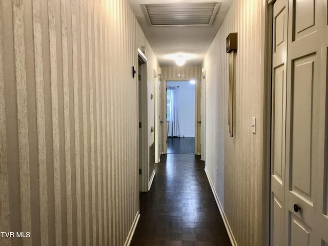 hallway with visible vents and baseboards