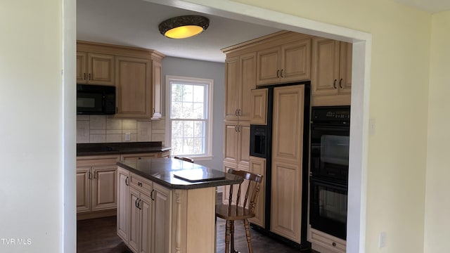 kitchen with decorative backsplash, dark countertops, a kitchen island, black appliances, and a kitchen breakfast bar