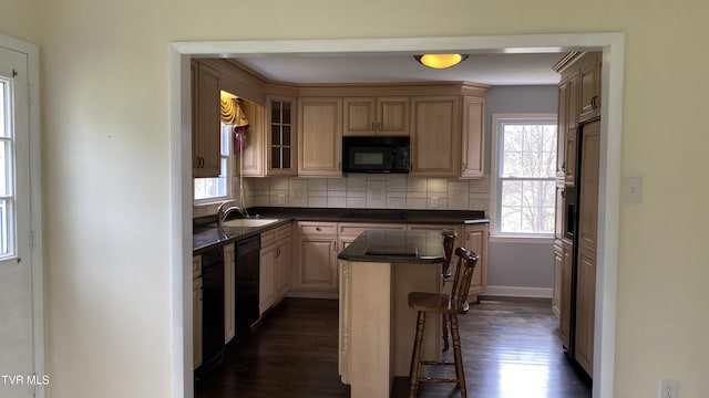 kitchen with tasteful backsplash, a center island, dark wood-type flooring, a sink, and black appliances