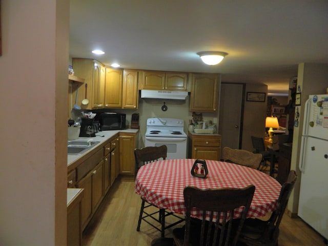 kitchen with white appliances, light hardwood / wood-style flooring, and sink