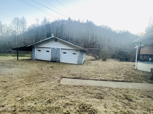 view of outdoor structure featuring a garage and a carport