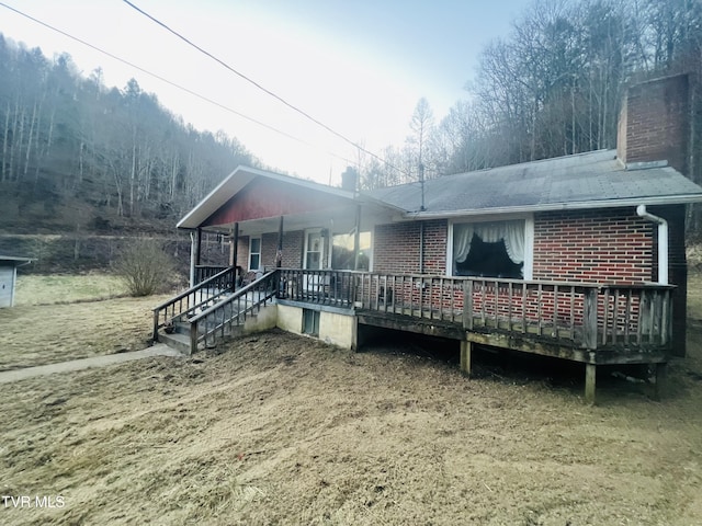 rear view of house with a porch and a deck