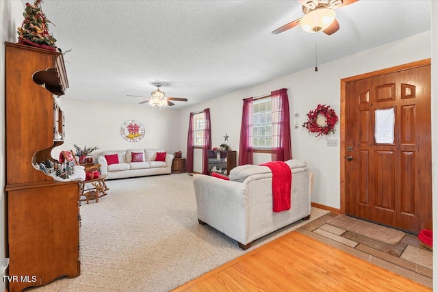 living room with a textured ceiling, hardwood / wood-style flooring, and ceiling fan