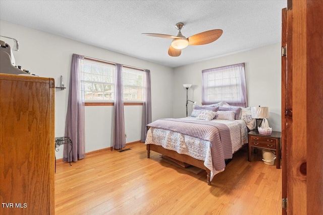 bedroom featuring a textured ceiling, light wood-type flooring, and ceiling fan