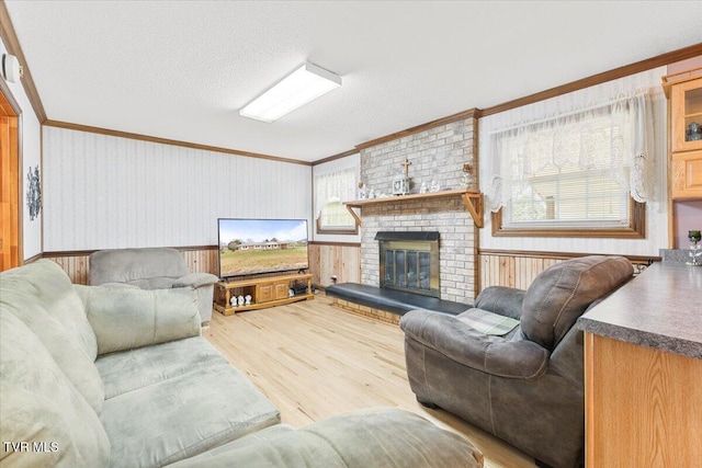 living room featuring plenty of natural light, hardwood / wood-style floors, a textured ceiling, and a brick fireplace