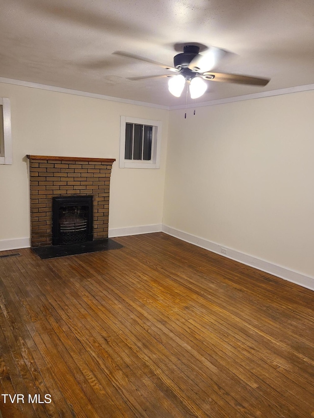 unfurnished living room featuring crown molding, a fireplace, ceiling fan, and dark hardwood / wood-style floors