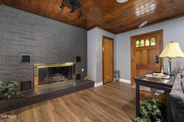 unfurnished living room featuring wood ceiling, crown molding, wood-type flooring, and a brick fireplace