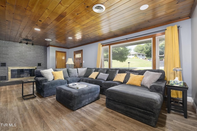 living room featuring a stone fireplace, crown molding, wood ceiling, and hardwood / wood-style flooring