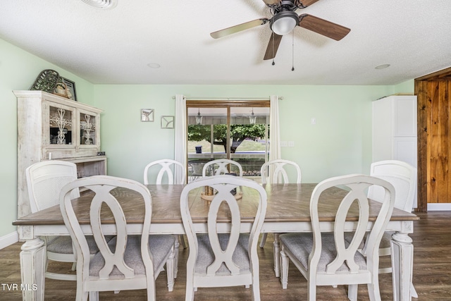 dining area featuring ceiling fan, dark wood-type flooring, and a textured ceiling