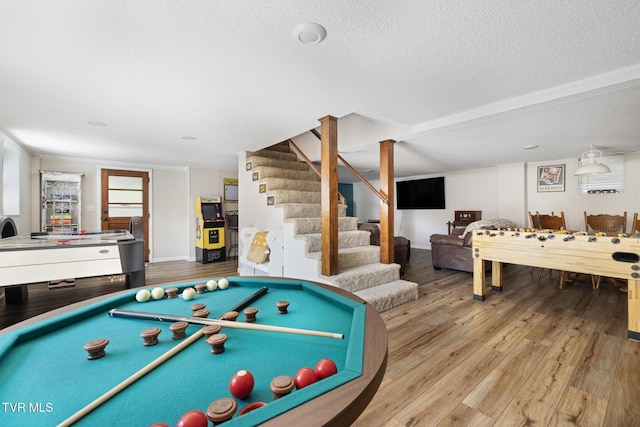 recreation room featuring a textured ceiling, light wood-type flooring, and billiards