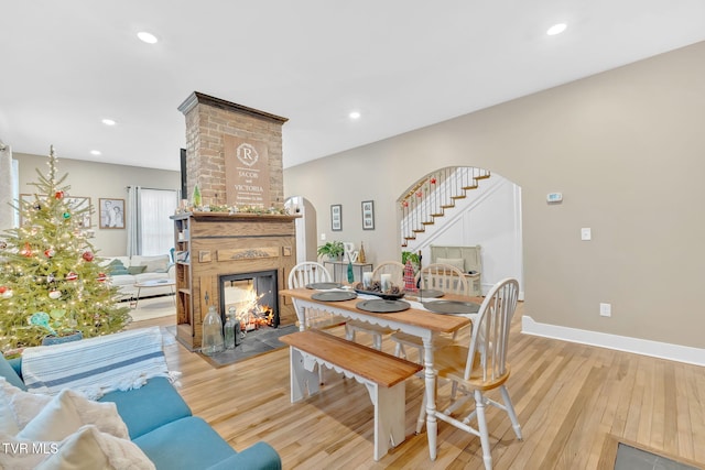 dining area featuring a large fireplace and light hardwood / wood-style floors