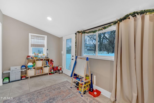 recreation room featuring light tile patterned floors and vaulted ceiling