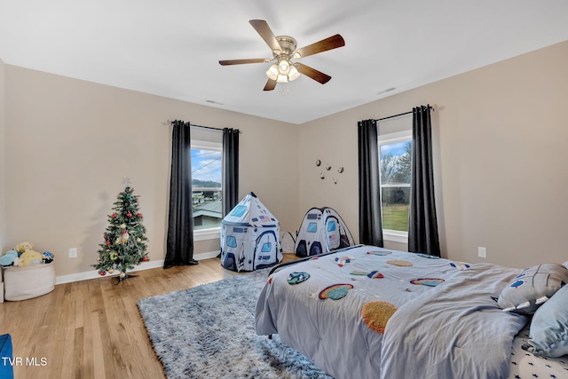 bedroom featuring multiple windows, ceiling fan, and light hardwood / wood-style floors