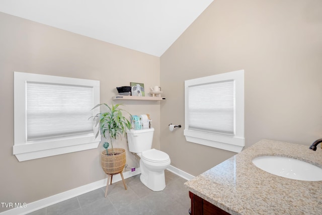 bathroom with tile patterned flooring, vanity, toilet, and vaulted ceiling